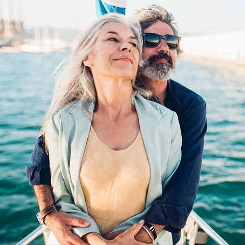An older couple embracing on the deck of a sailboat