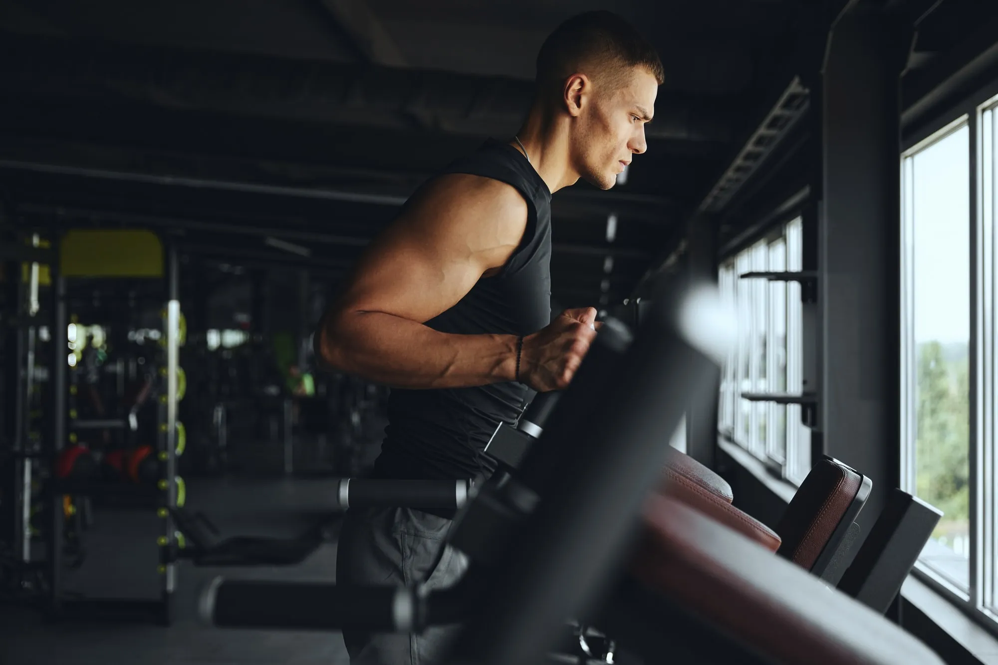 A man running on a treadmill beside a window